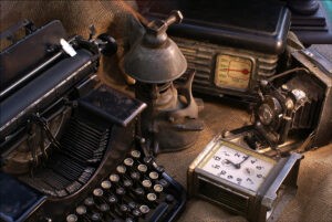 An image of antiques like a typewriter, clock, and stereo.