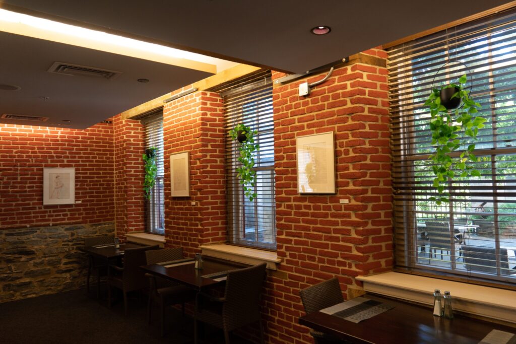 a brick wall in a restaurant with tables and chairs