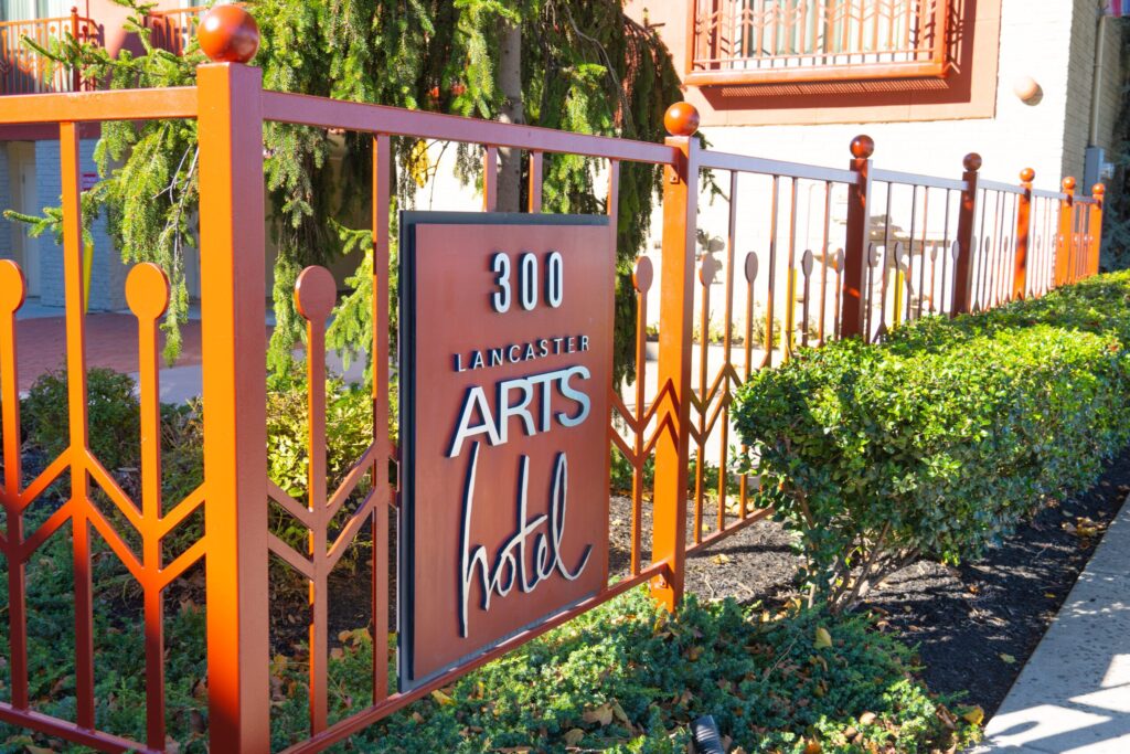 an orange gate with a sign that says arts hold