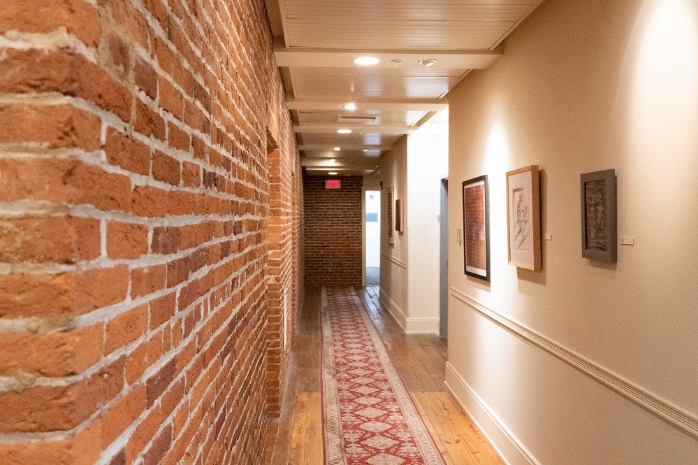 a long hallway with red and white rugs on the floor