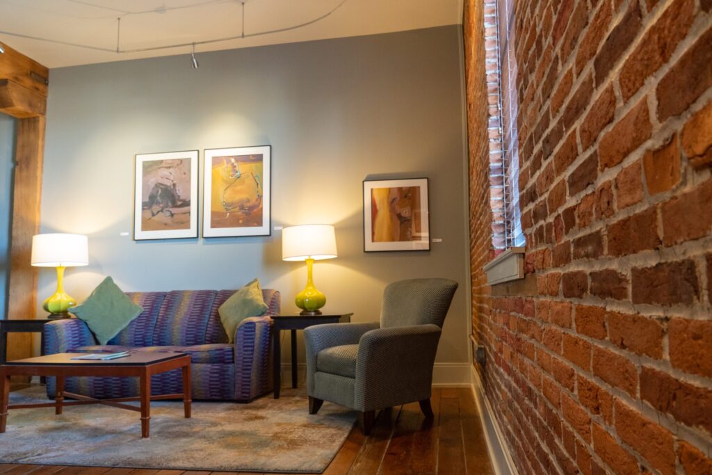 a living room filled with furniture next to a brick wall