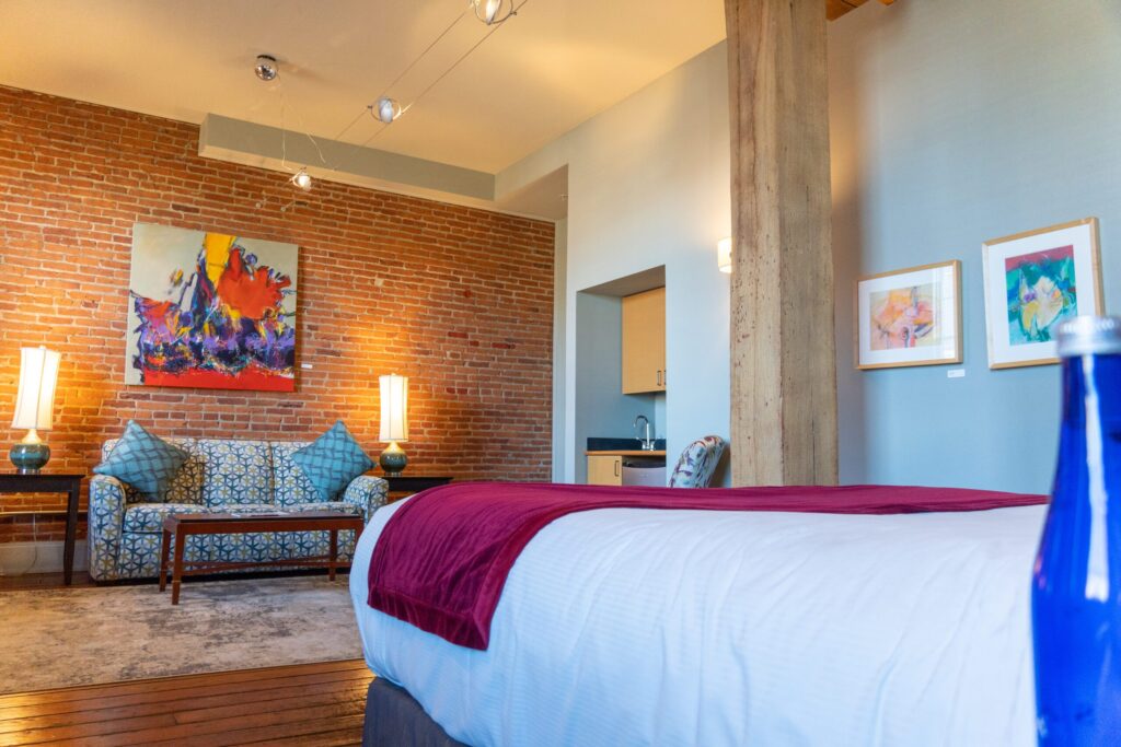 a bedroom with a brick wall and wooden floors
