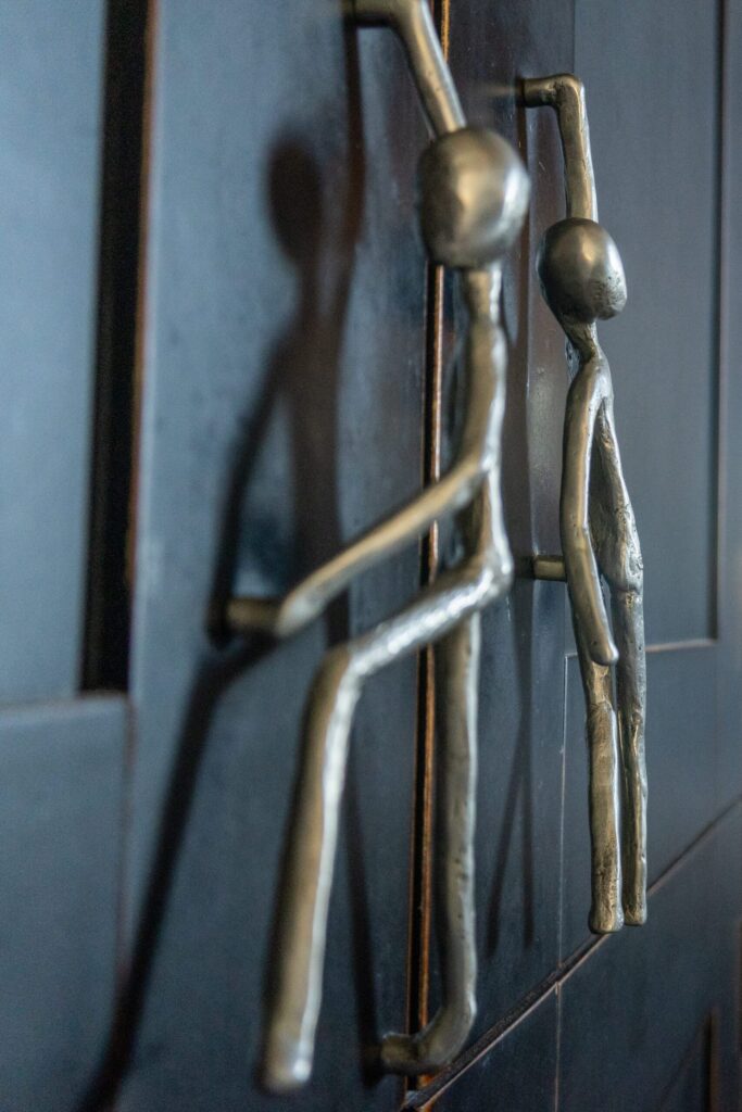 a metal figure hanging on the side of a door