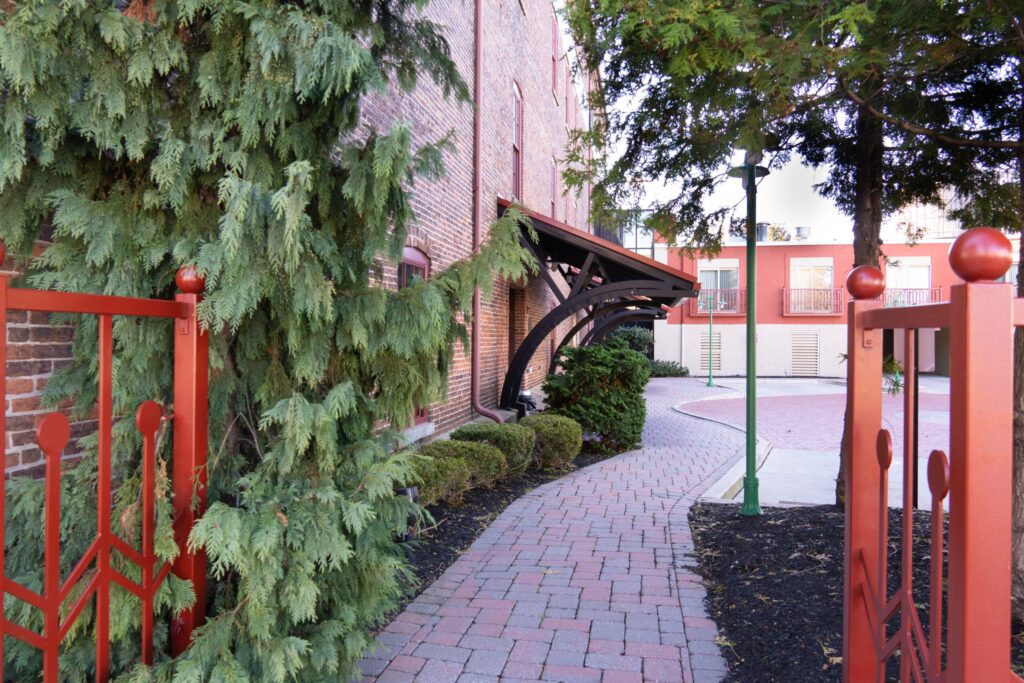 a brick walkway between two buildings and trees