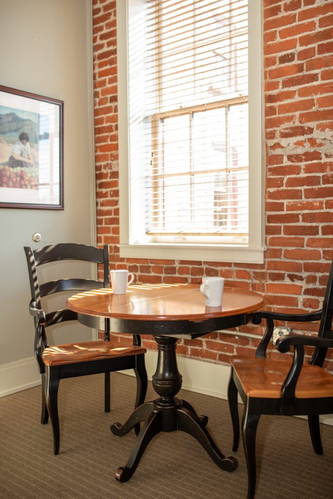 a table and two chairs in front of a brick wall