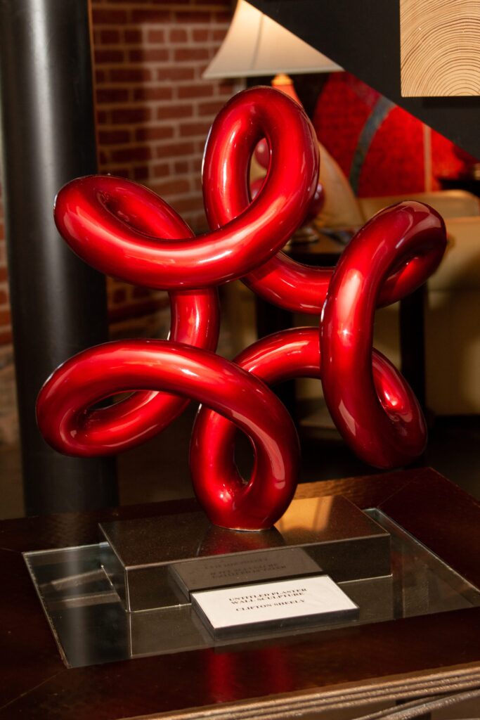 a red balloon sculpture sitting on top of a wooden table