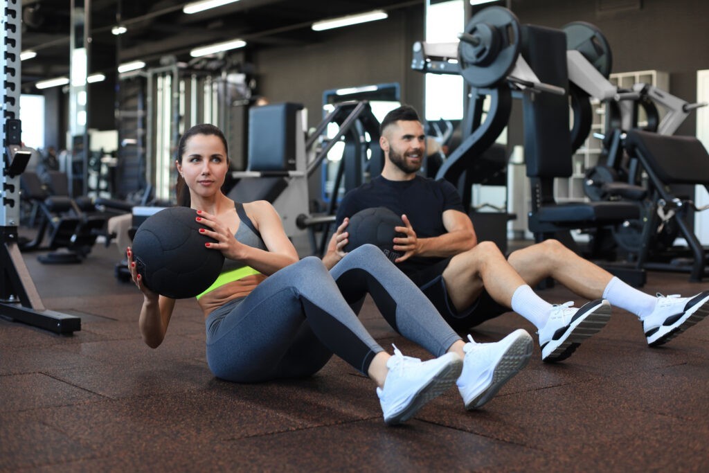 two people sitting on the ground in a gym