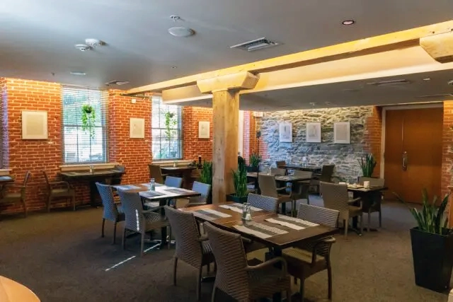 a restaurant with tables, chairs and brick walls