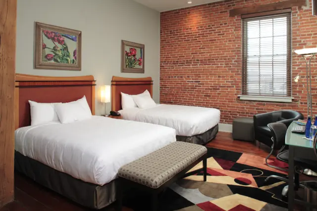 two beds in a room with brick walls