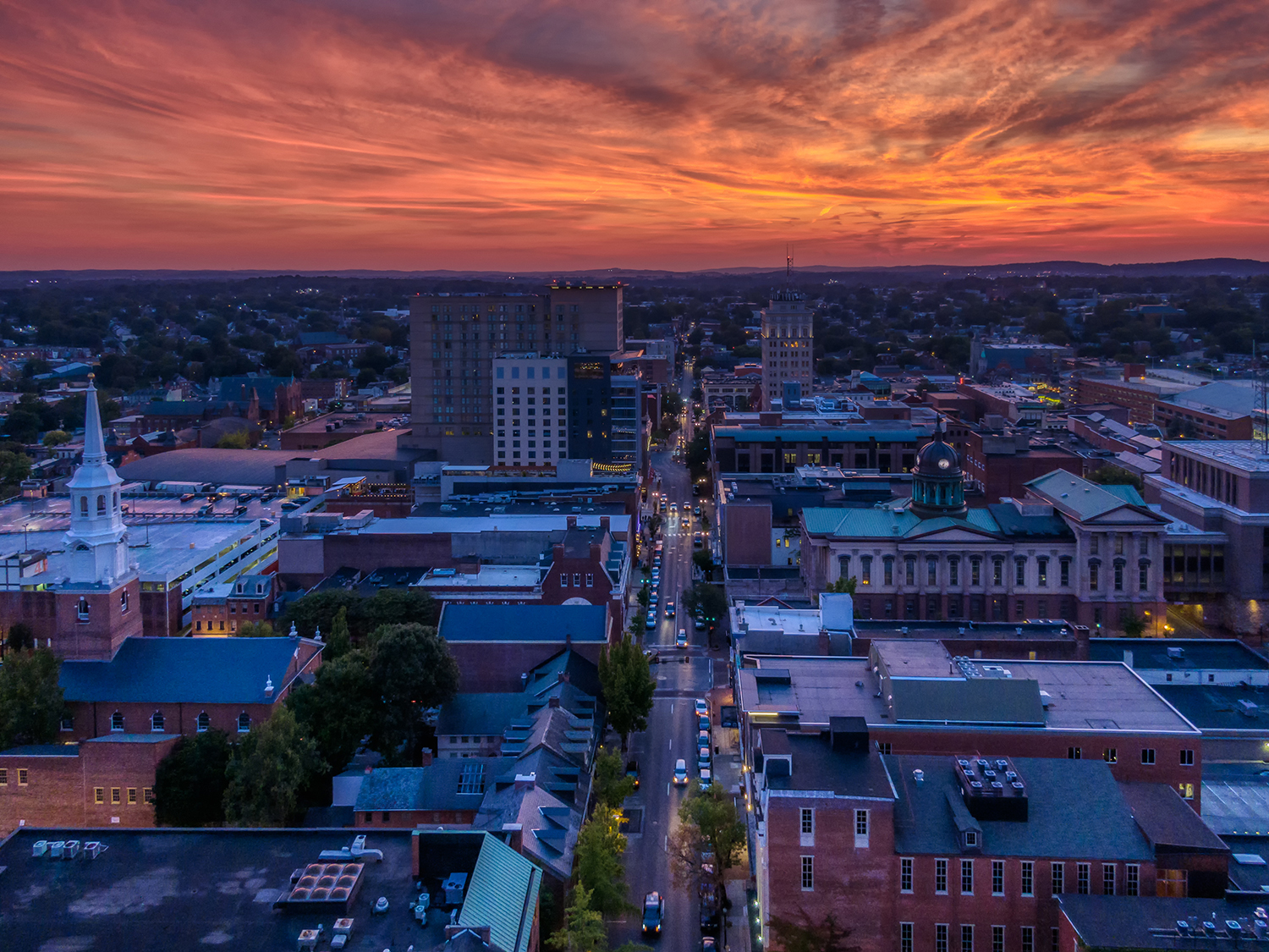 downtown Lancaster at dusk, with cars on the road