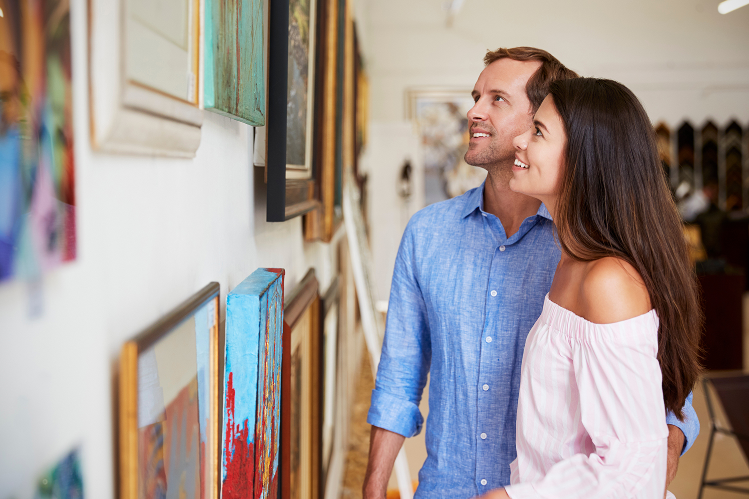 a couple looking at paintings in an art gallery