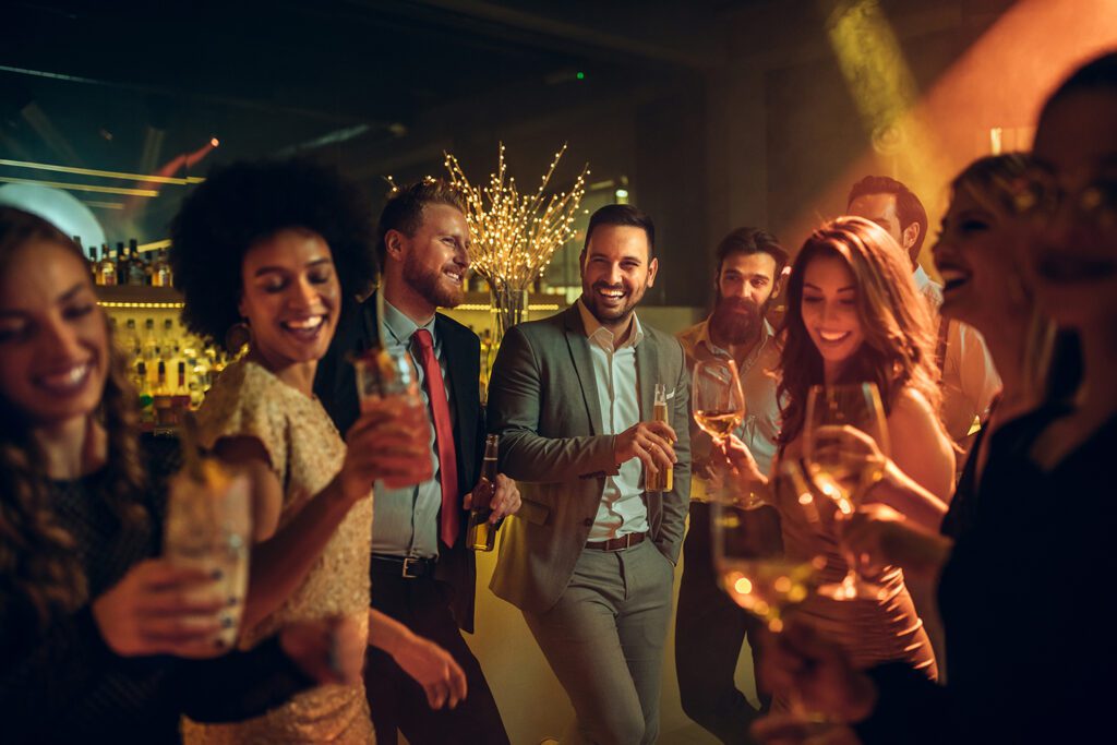 A group of people enjoying a holiday party, smiling and laughing.